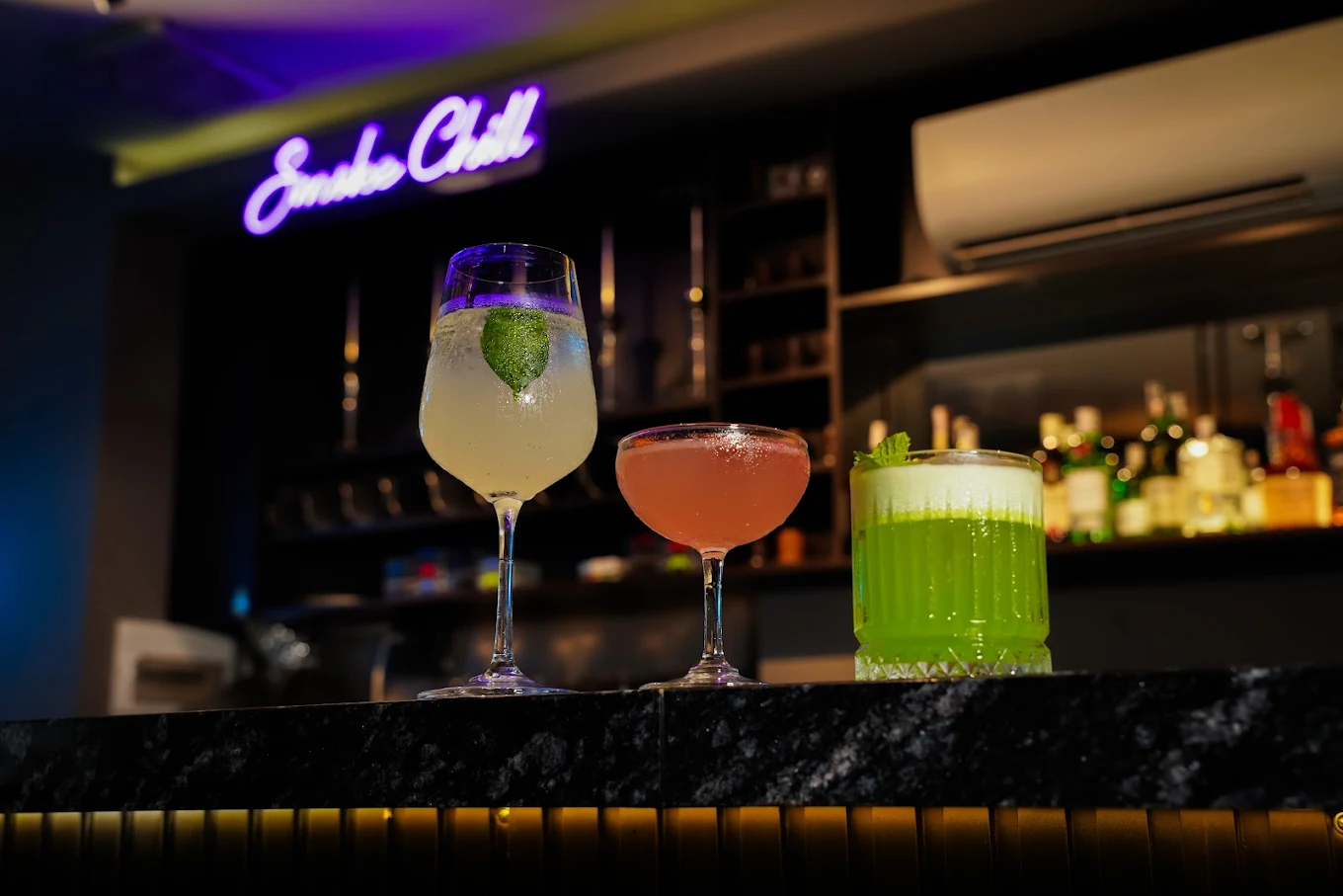 Signature cocktails at Chilllayla with Smoke Chill neon sign