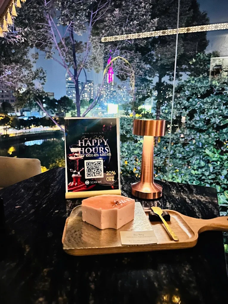 Outdoor terrace table with hookah and Saigon night skyline