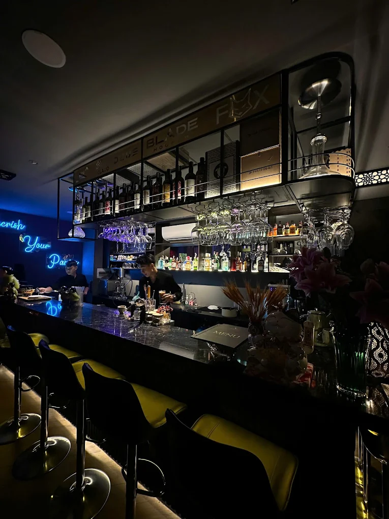 Bartender preparing drinks at the moody neon-lit bar