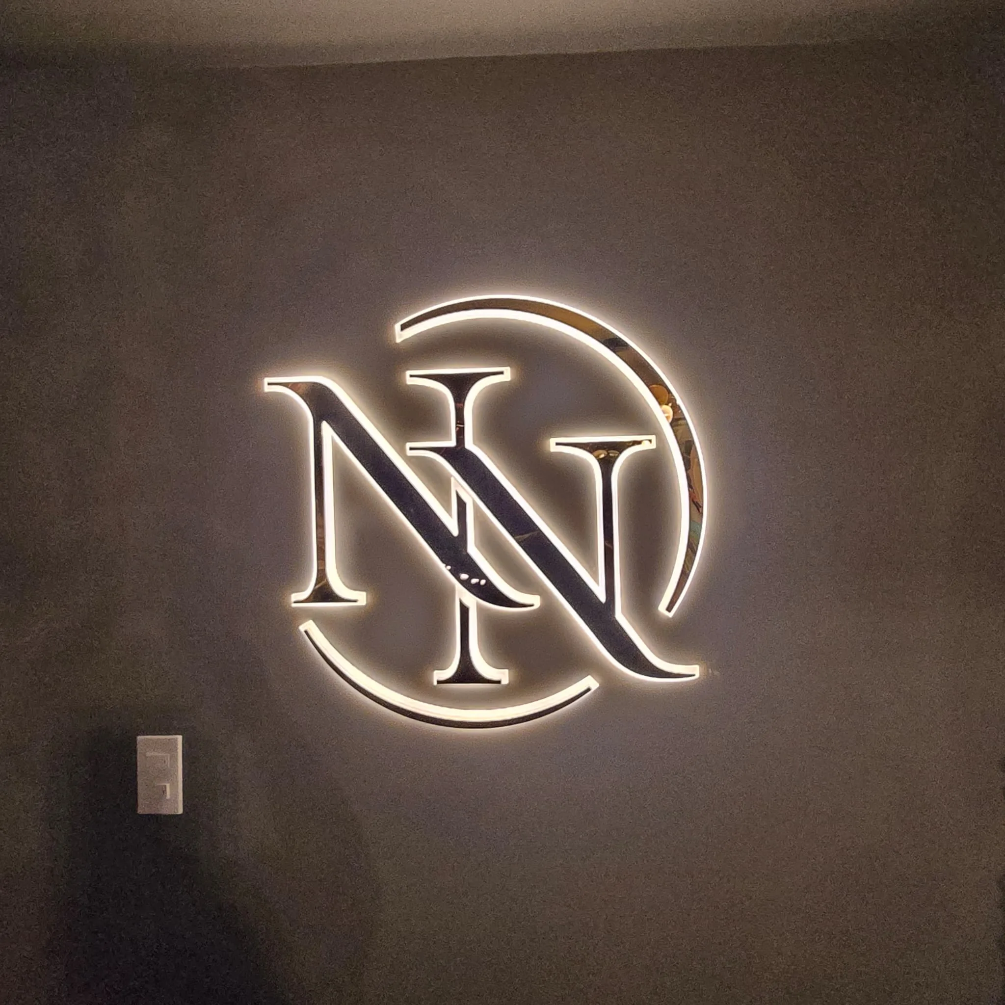Illuminated Natasha Noir monogram sign on the lounge wall